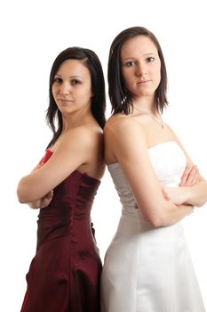 two young women in dresses standing back on back