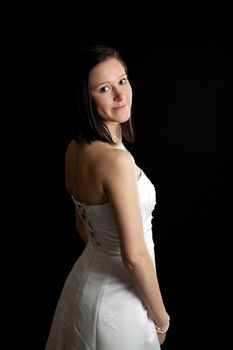 a young woman in a white dress looking backward over her shoulder