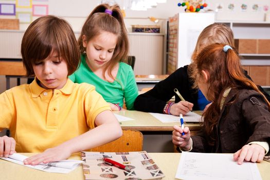 Group of little students with different ages in a classroom