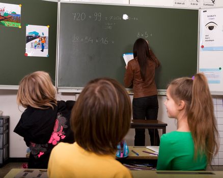 Group of little students with different ages in a classroom