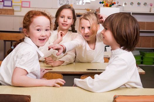 Group of little students with different ages in a classroom