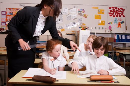 Group of little students with different ages in a classroom