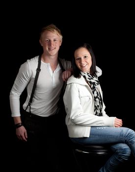 a young man leaning on a young woman posing