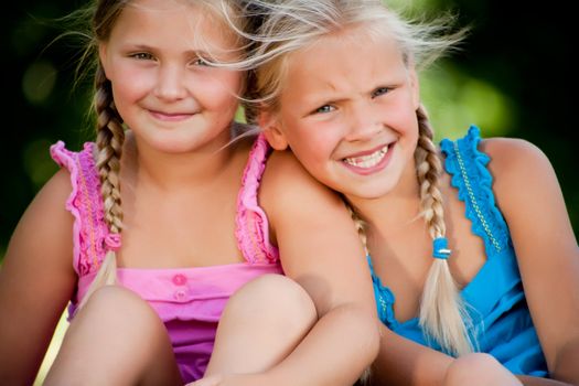 Two little girls in fresh colors in the park