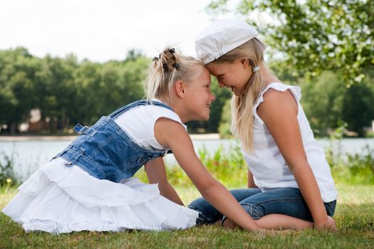 Two little girls in fresh colors in the park