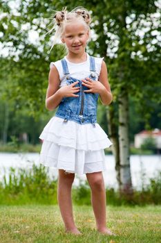 Sweet little girl in jeans on the grass