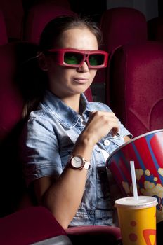 young woman sitting alone in the cinema and watching a movie