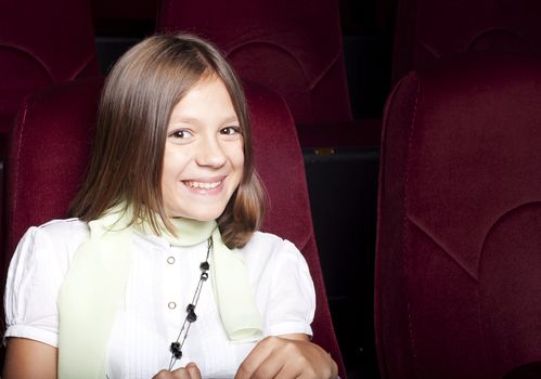girl sitting alone in the cinema and smile
