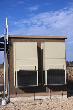 Equipment shelter on the cellular site. GPS antenna on the left.