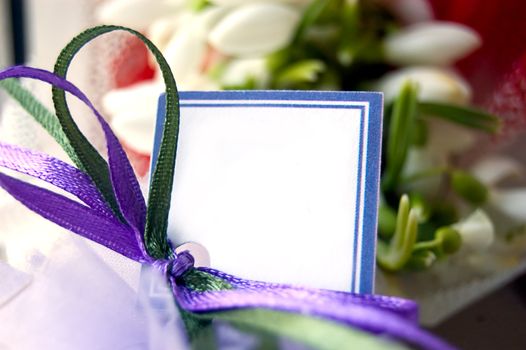 Blank note with ribbons over snowdrop bouquet