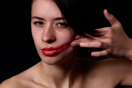 Young mult etnic woman making a mess of her lipstick