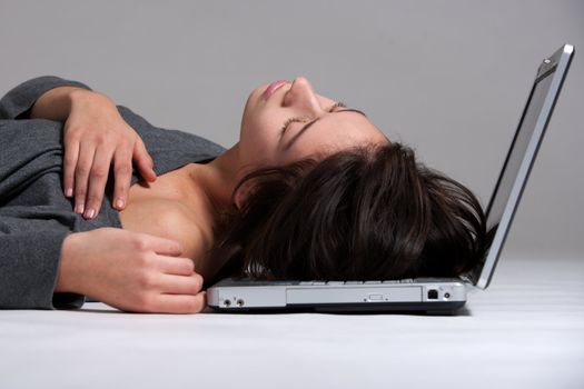 Studio shot of a multi raced yopung woman with her laptop on the floor