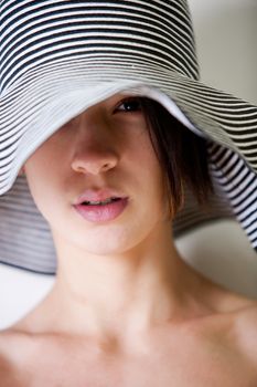 Studio portrait of a young mult racial young woman with hat