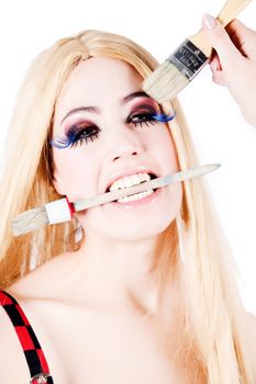 Portrait of a blond long haired girl with make-up brushes
