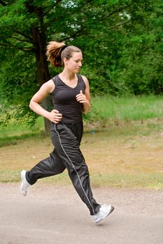 Young adult jogging on a forest road