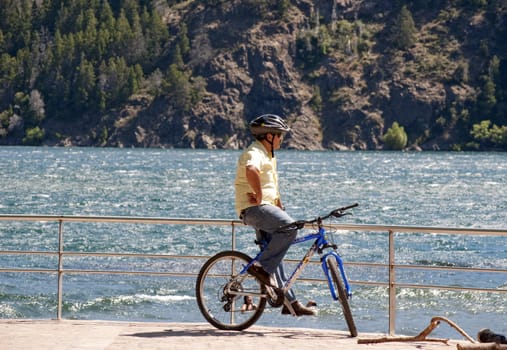 Man on bicycle looking at the lake Lacar in San Martin de los Andes, Patagonia Argentina