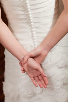 back of the white wedding dress and hands