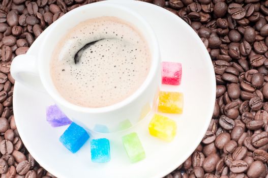 Shot of multicolored slabs of shugar and cup of coffee