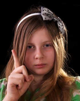 Young girl scolding and shaking her finger on black