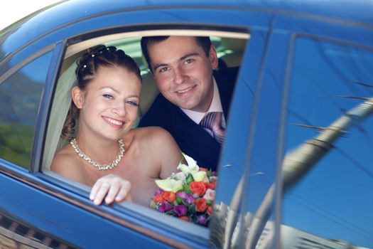 portrait of bride and groom in the car