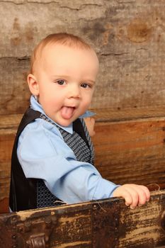 Baby boy playing inside an antique trunk