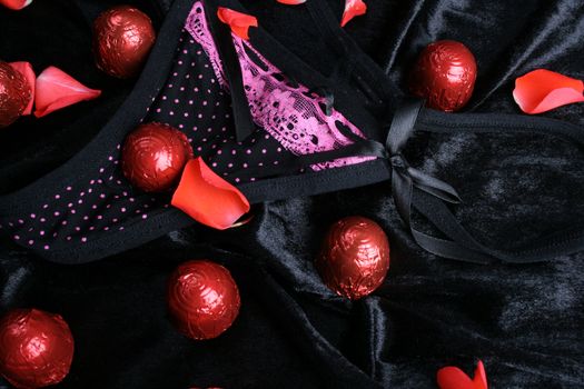 Lace polkadot underwear and chocolates with rose petals