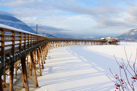 Wooden pier with snow at frozen lake in Salmon Arm