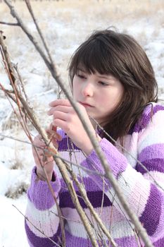 Young brunette teen playing in the field after the snowfall 
