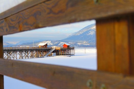 Wooden pier with snow at frozen lake in Salmon Arm 
