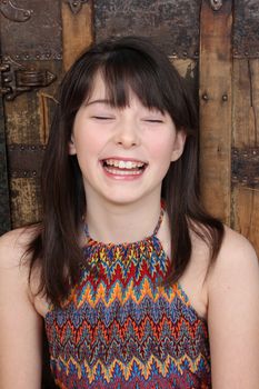 Beautiful brunette teen against a wooden background