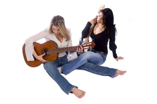 two female guitarists practicing while sitting on the floor on a white background