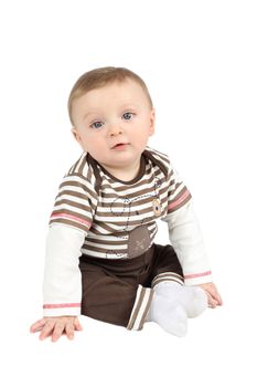 Cute baby boy sitting against a white background