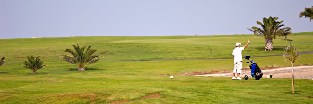 Man is checking the wind direction at exotic golf course