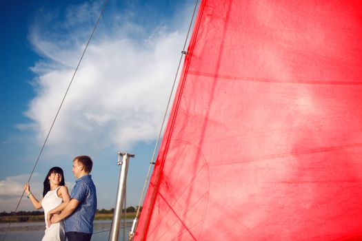 man and girl under the red sail