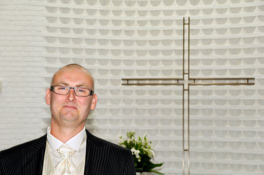 Groom in church is waiting for his bride