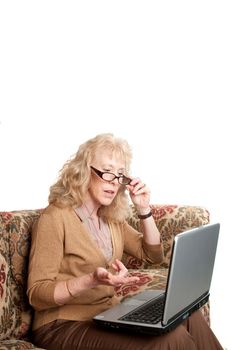 older woman studying finances on a laptop computer