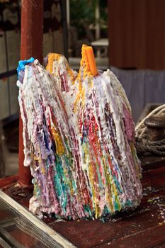 Colourful wax drips from old candles in a bottle