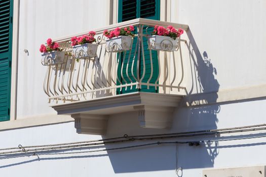 Pink flowers in window boxes on a balcony