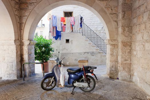 Retro moped under an arch in Italy