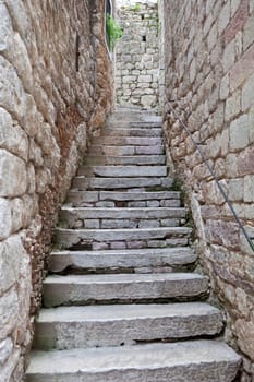 Old stone stairs between two stone walls