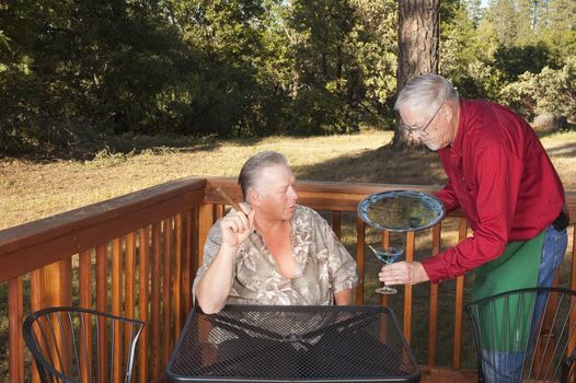 Waiter delivering a cocktail to a customer at an outdoor restaurant/bar