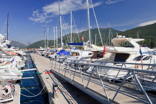 Luxury yachts at dock against a floating jetty