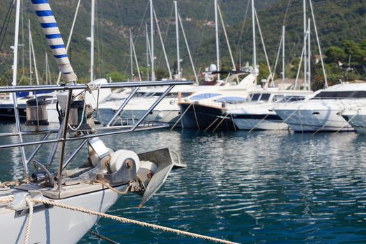 Sailboat bow and anchor with luxury power yachts