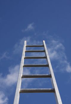 Bright silver ladder against a blue sky 