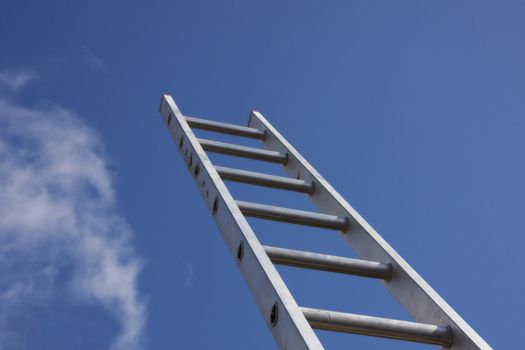 Bright silver ladder against a blue sky 