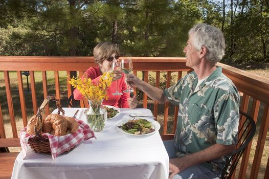 couple enjoying a dinner in an outdoor restaurant toasting each other