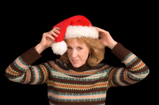 older woman in Santa hat over a black background