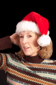 older woman in Santa hat over a black background