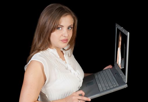 Fashion model holding laptop computer checking photographers images over a black background