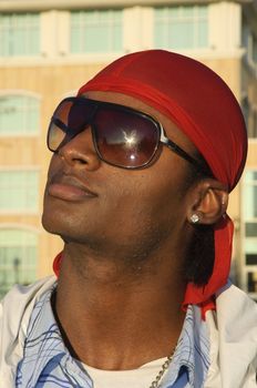 closeup of a young African American man wearing sunglasses in an outdoor setting